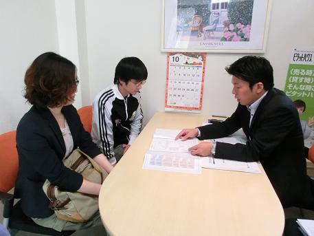 不動産屋さんで契約書を交わすD様ご夫婦